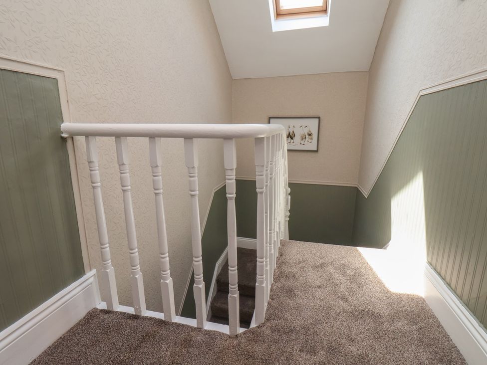 A staircase with a handrail and artwork on the wall at Crescent Bay House