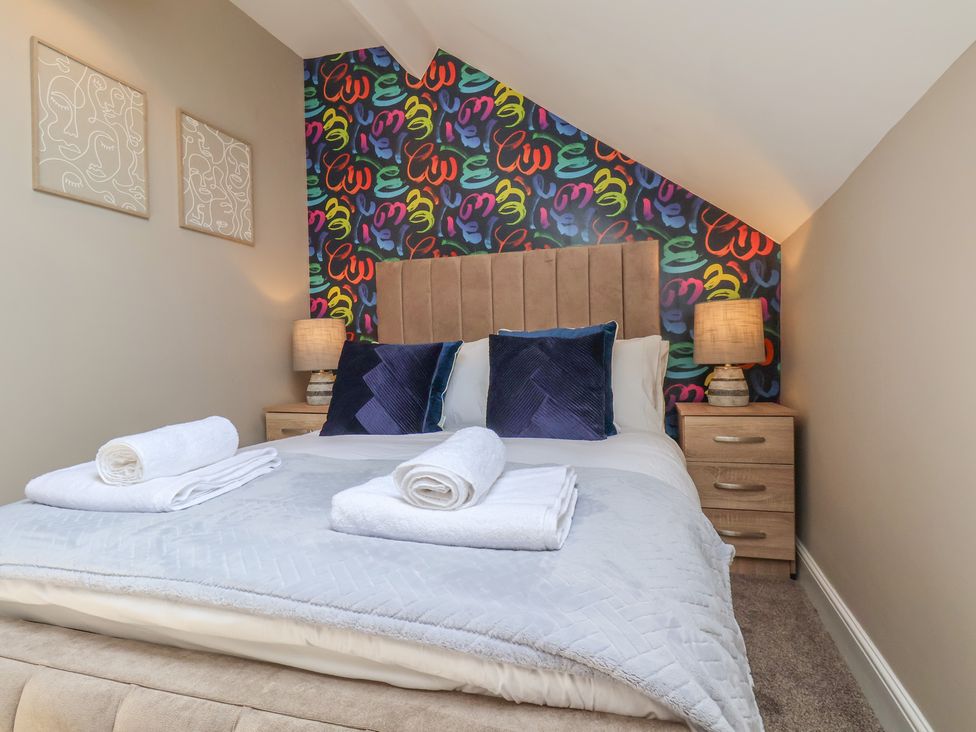 A bedroom with a bed and decorative wall at Crescent Bay House