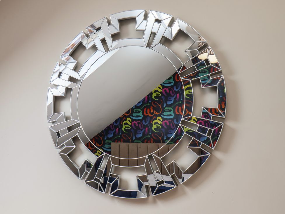 A decorative round mirror with a patterned background at Crescent Bay House 