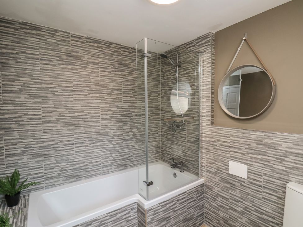 A bathroom with a bathtub and shower at Crescent Bay House