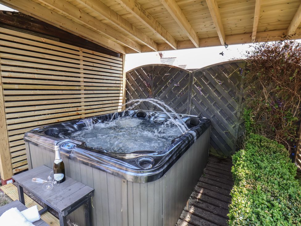 A hot tub with a table and champagne at Crescent Bay House