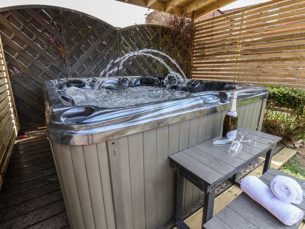 A hot tub with champagne and glasses on a table at Crescent Bay House