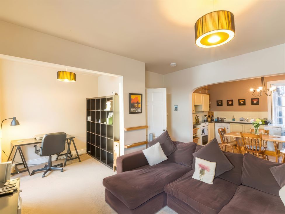 A living room with a sofa and desk at River Cottage in Inverness