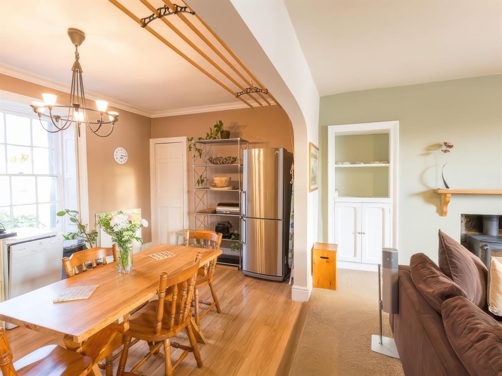 A dining room with a table and chairs at River Cottage in Inverness