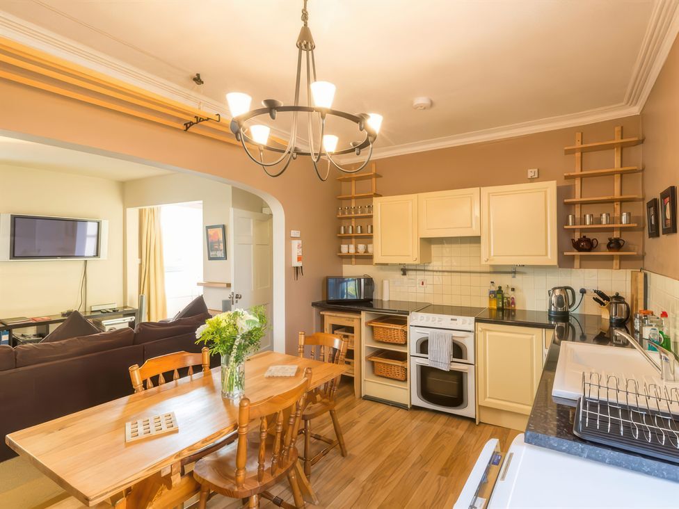 A kitchen with a dining table and television at River Cottage in Inverness