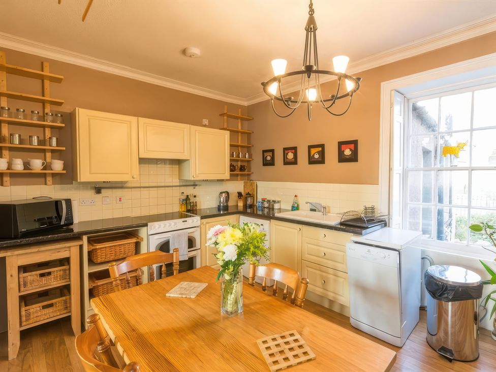 A kitchen with a dining table and appliances at River Cottage in Inverness