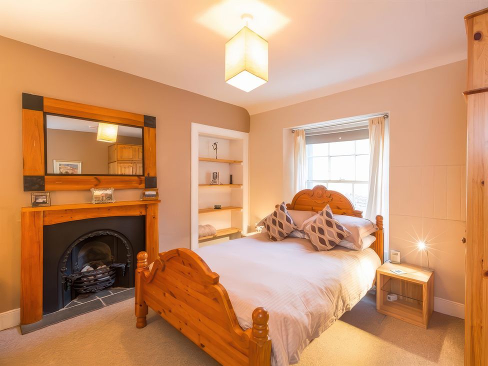 A bedroom with a bed and fireplace at River Cottage in Inverness