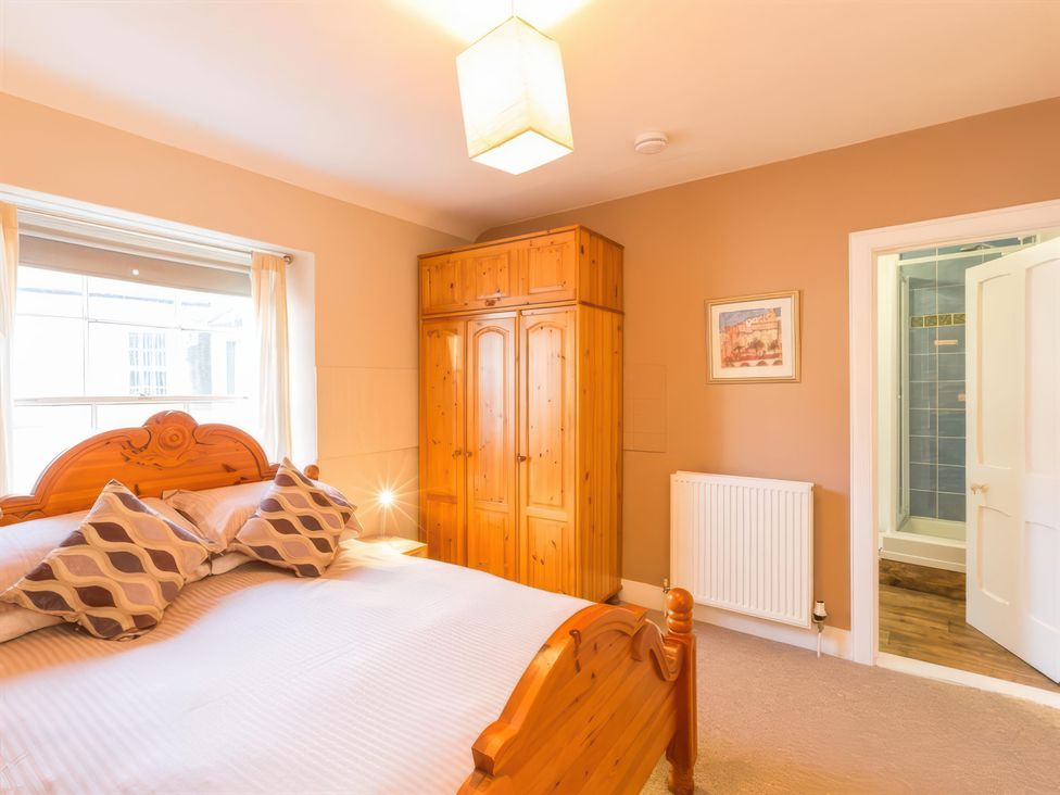 A bedroom with a bed and wardrobe at River Cottage in Inverness