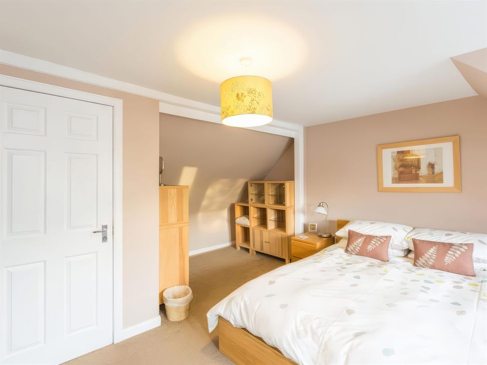 A bedroom with a bed and bookshelf at River Cottage in Inverness