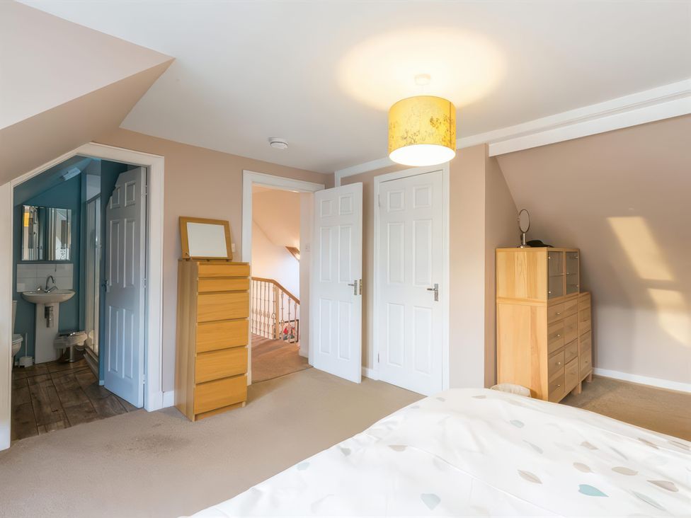 A bedroom with a bed and wooden furniture at River Cottage in Inverness