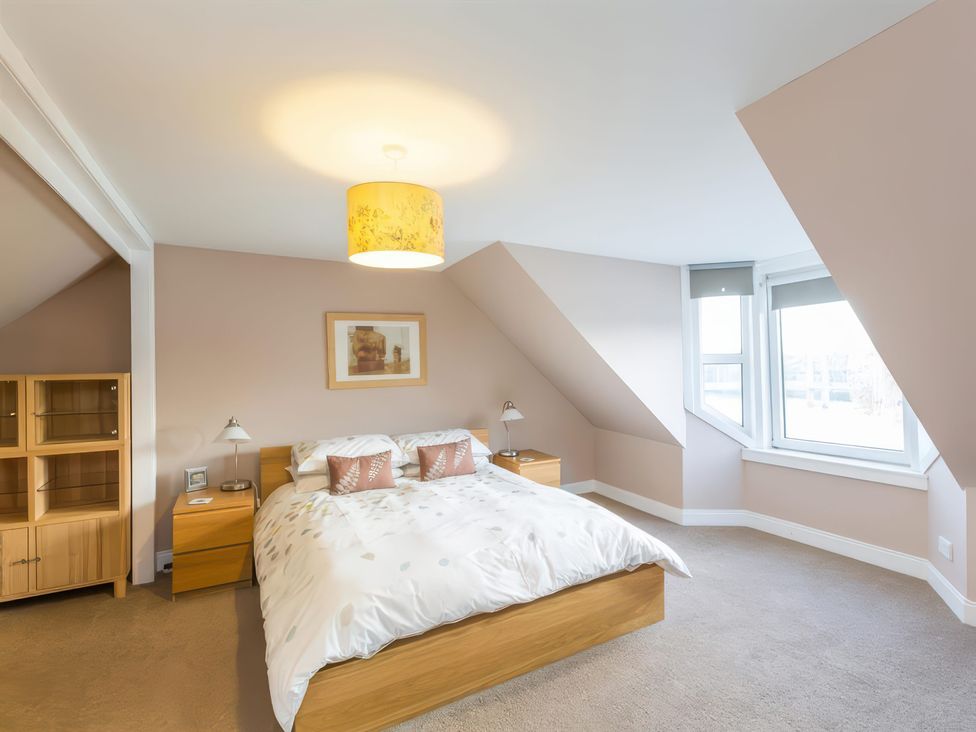 A bedroom with a bed and nightstands at River Cottage in Inverness