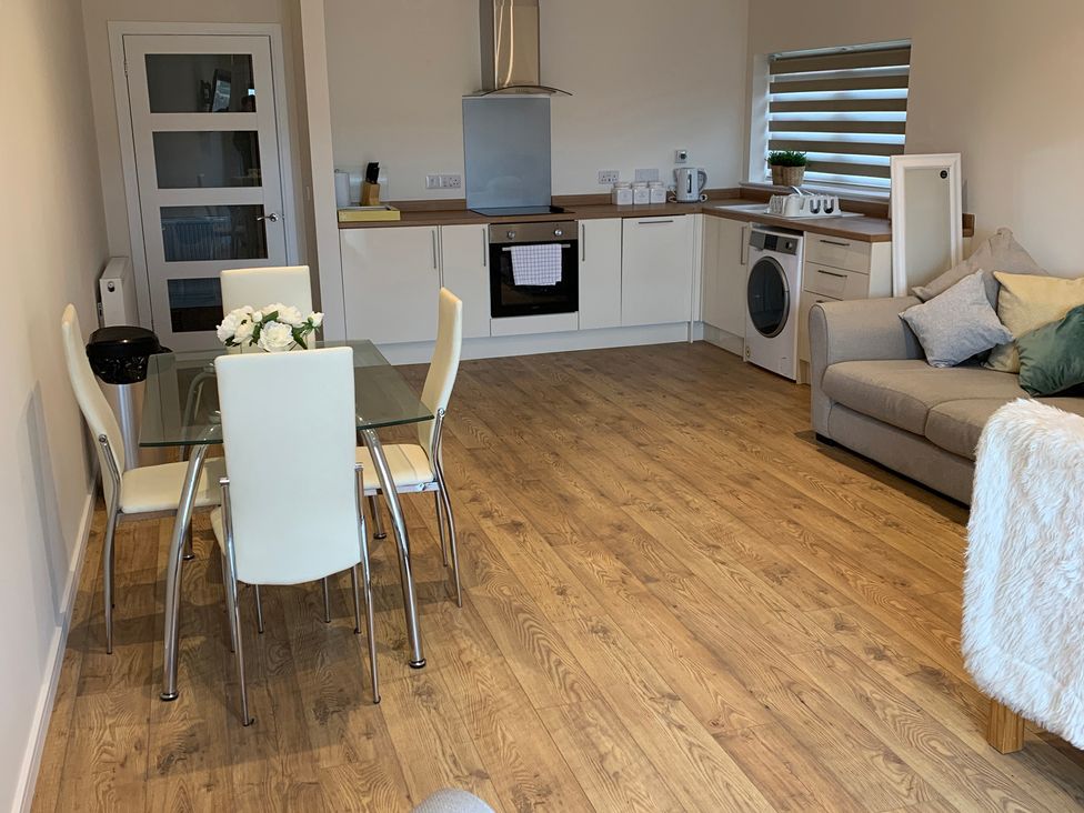 A living room with a dining area and kitchen appliances at View Apartment in Inverness