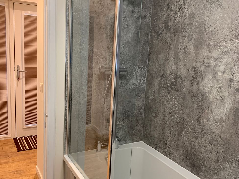 A bathroom featuring a shower and bathtub at View Apartment in Inverness
