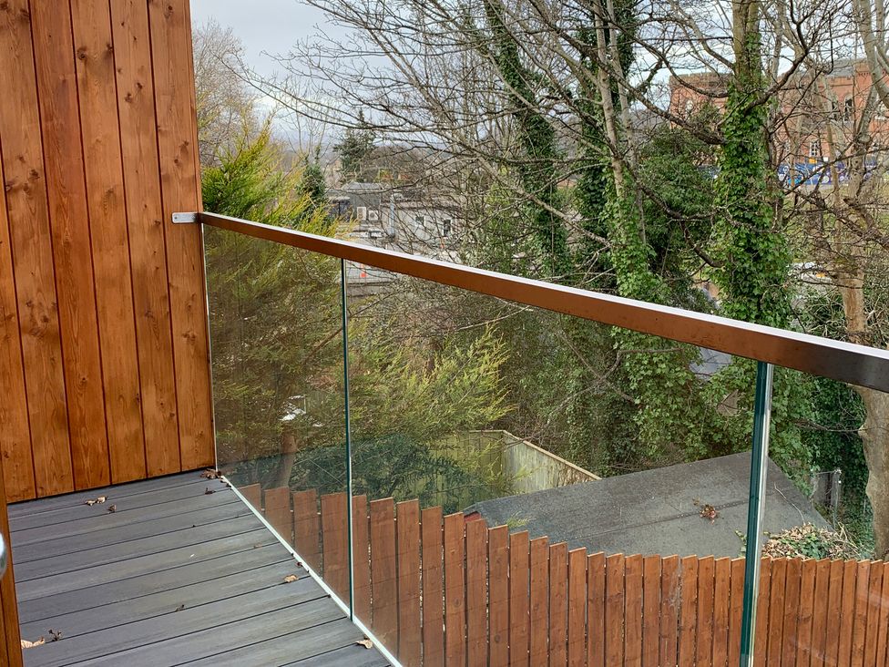 A balcony with wooden railing and glass panel at View Apartment in Inverness