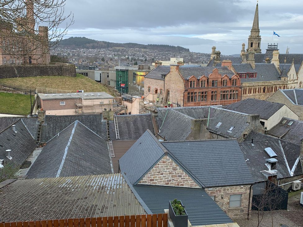 A view of rooftops and buildings with maintenance scaffolding at View Apartment Inverness