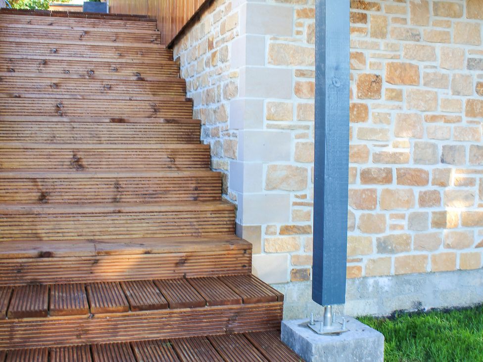 Stairs leading to an outdoor area with a stone wall at View Apartment in Inverness
