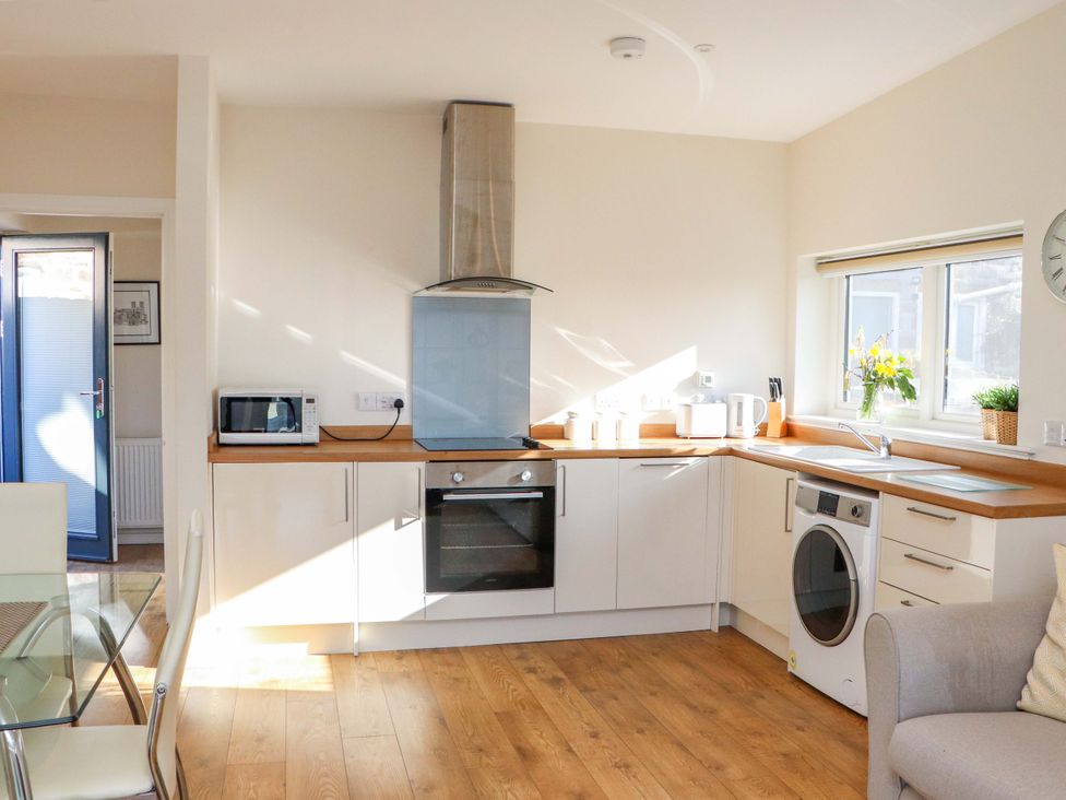A kitchen with appliances and a dining table at View Apartment in Inverness