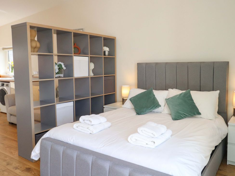 A bedroom with a bed and bookshelf at View Apartment in Inverness