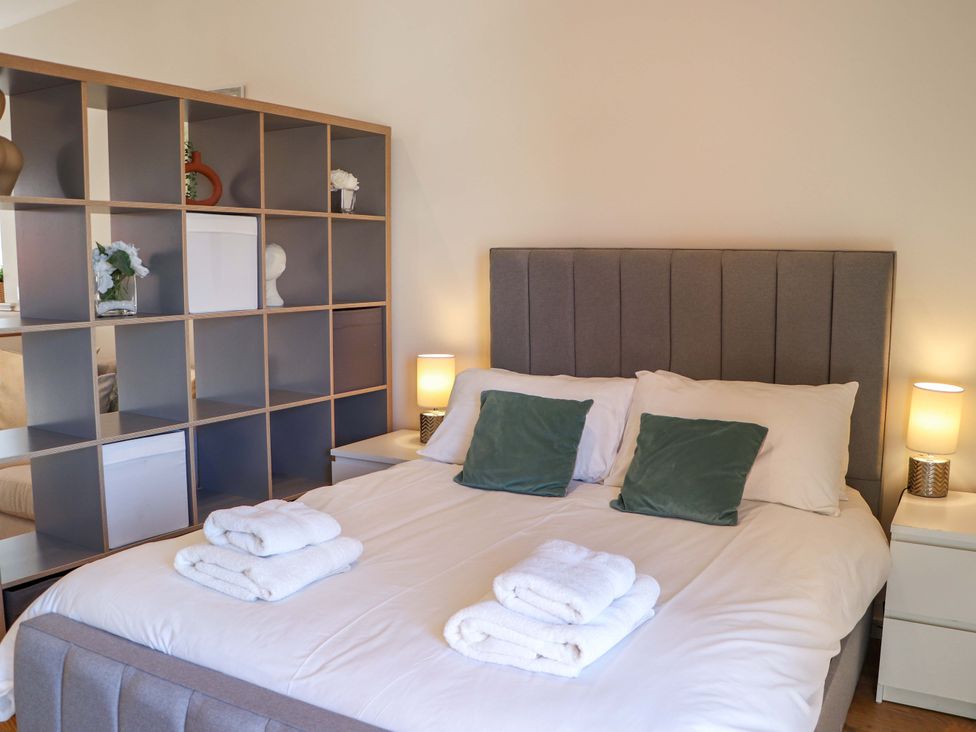 A bedroom with a bed and shelving unit at View Apartment in Inverness