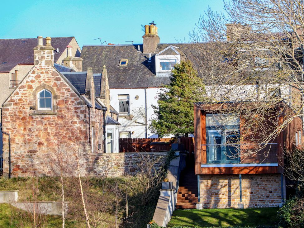 A view of a stone house and a modern house with stairs at View Apartment in Inverness