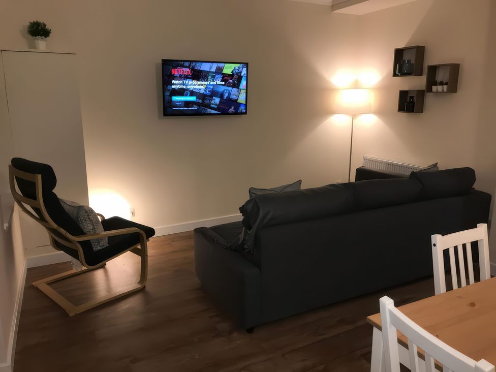 A living room with a TV and sofa at 2 Lower Kessock Street Inverness