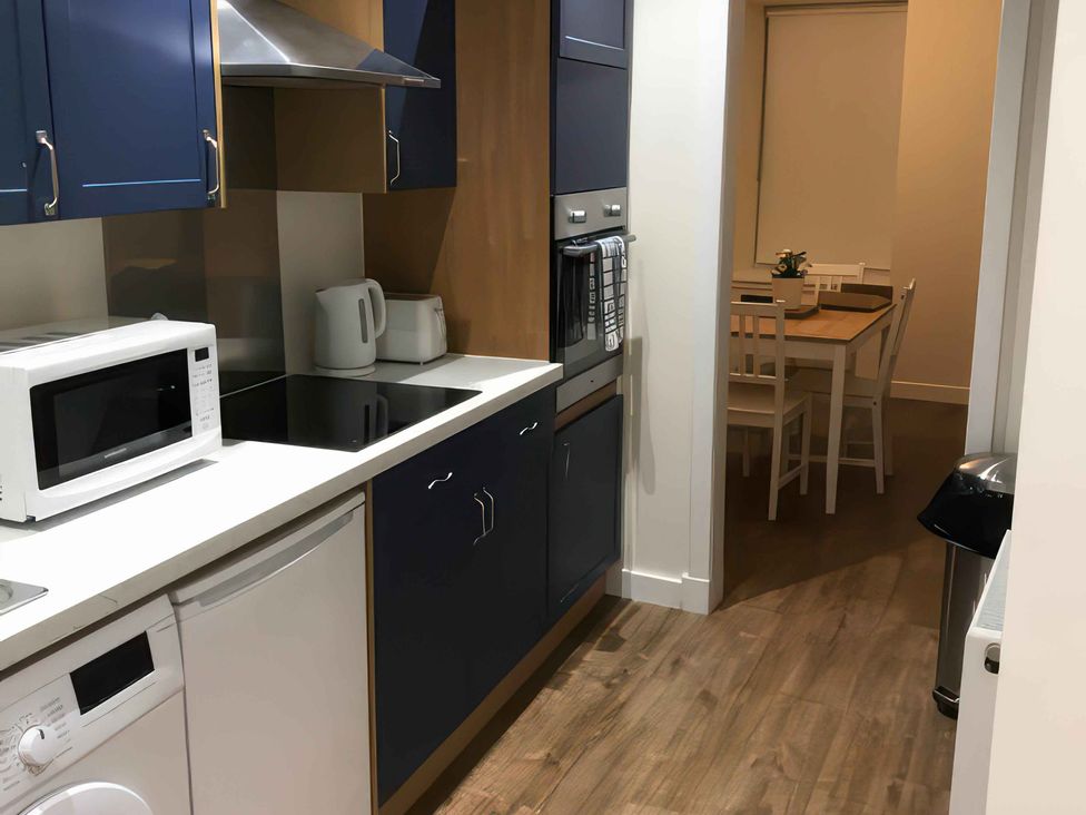 A kitchen with appliances and a dining area at 2 Lower Kessock Street Inverness