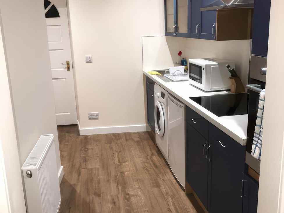 A kitchen with appliances and cabinets at 2 Lower Kessock Street in Inverness