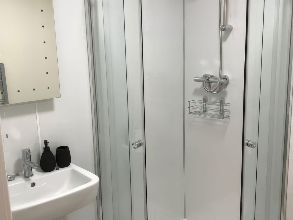 A bathroom with a shower and sink at 2 Lower Kessock Street in Inverness