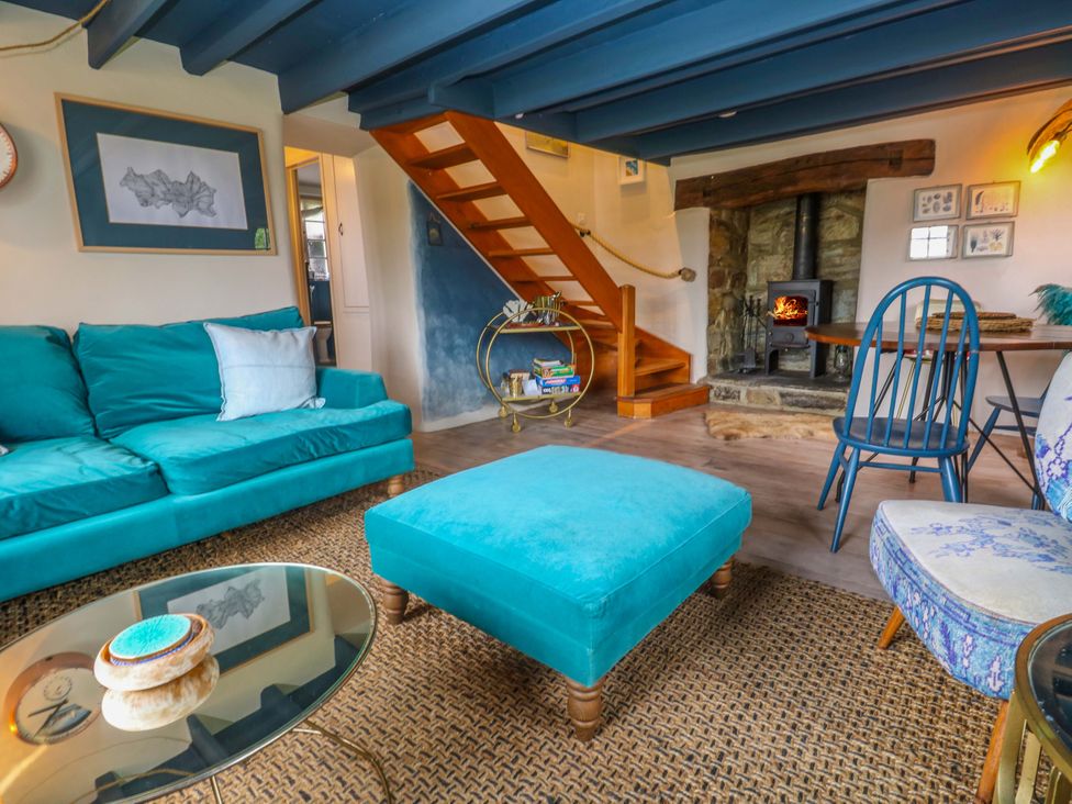A living room with a sofa and fireplace at Mermaid Cottage near Coverack near St Keverne
