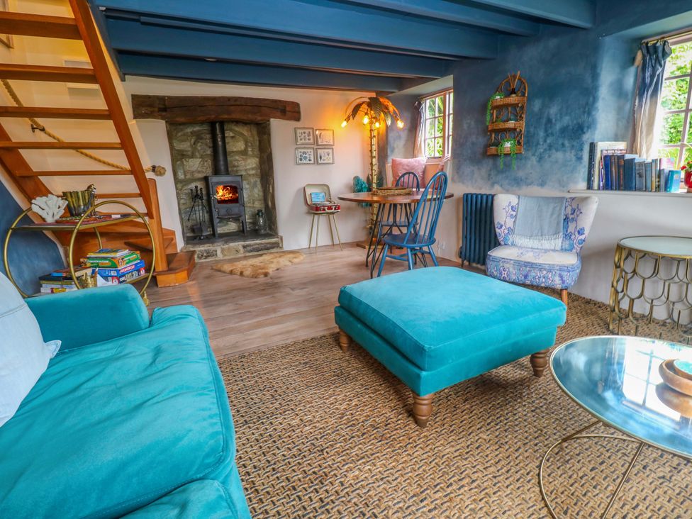 A living room with a fireplace and seating arrangements at Mermaid Cottage in Coverack near St Keverne