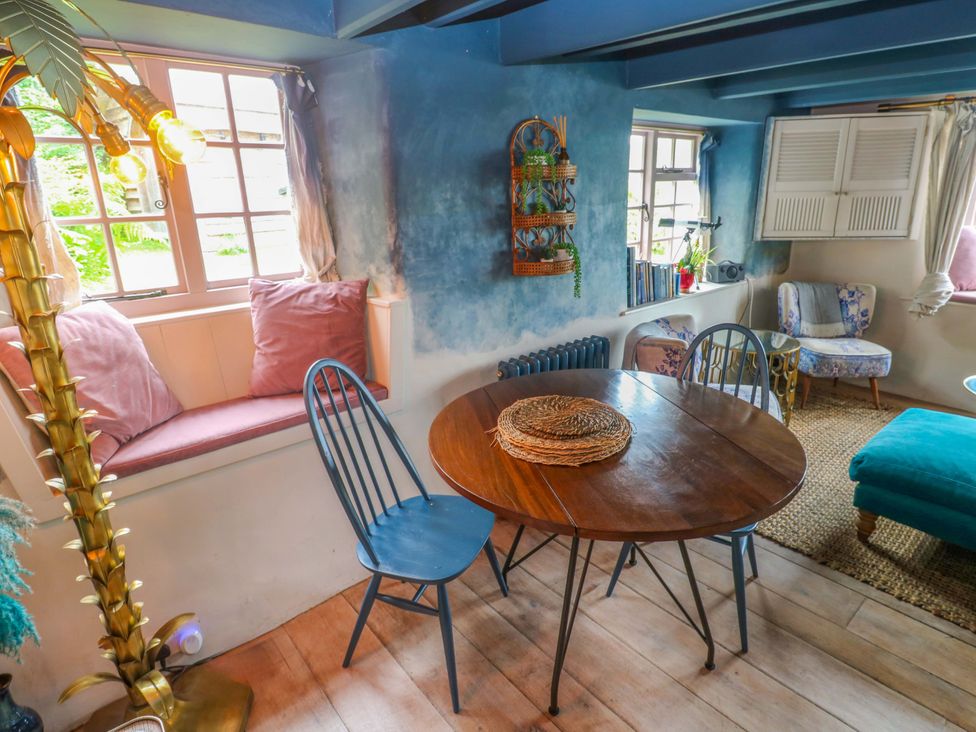 A dining room with a wooden table and chairs at Mermaid Cottage Coverack near St Keverne