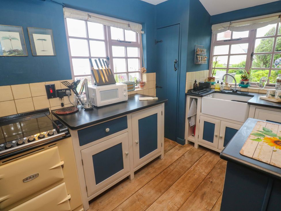 A kitchen featuring a sink, oven, microwave, and countertop at Mermaid Cottage Coverack near St Keverne