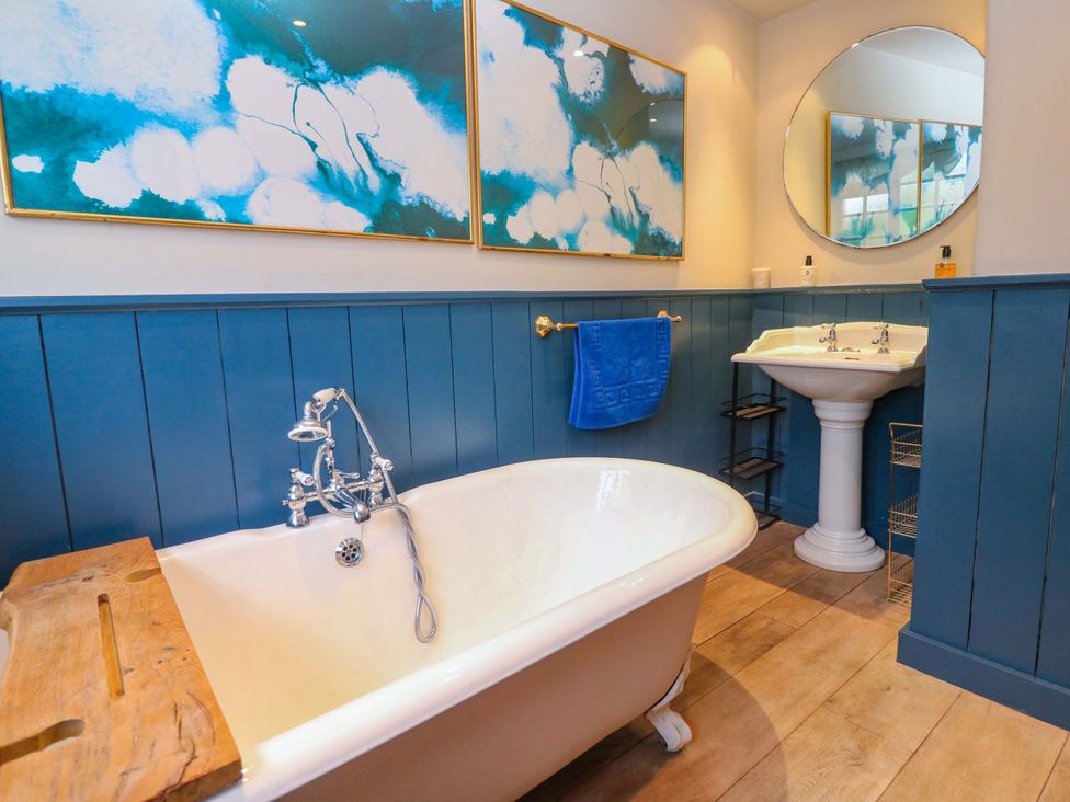 A bathroom with a bathtub and washbasin at Mermaid Cottage in Coverack near St Keverne