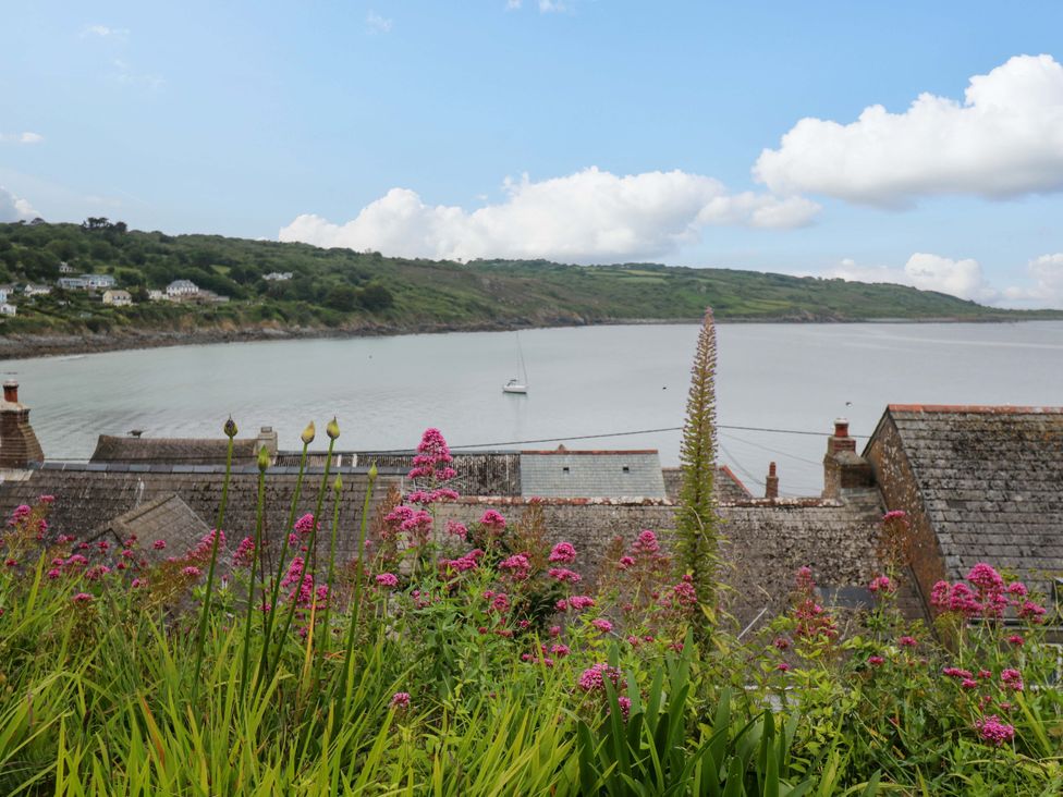 A view of a bay with flowers and houses at Mermaid Cottage in Coverack near St Keverne