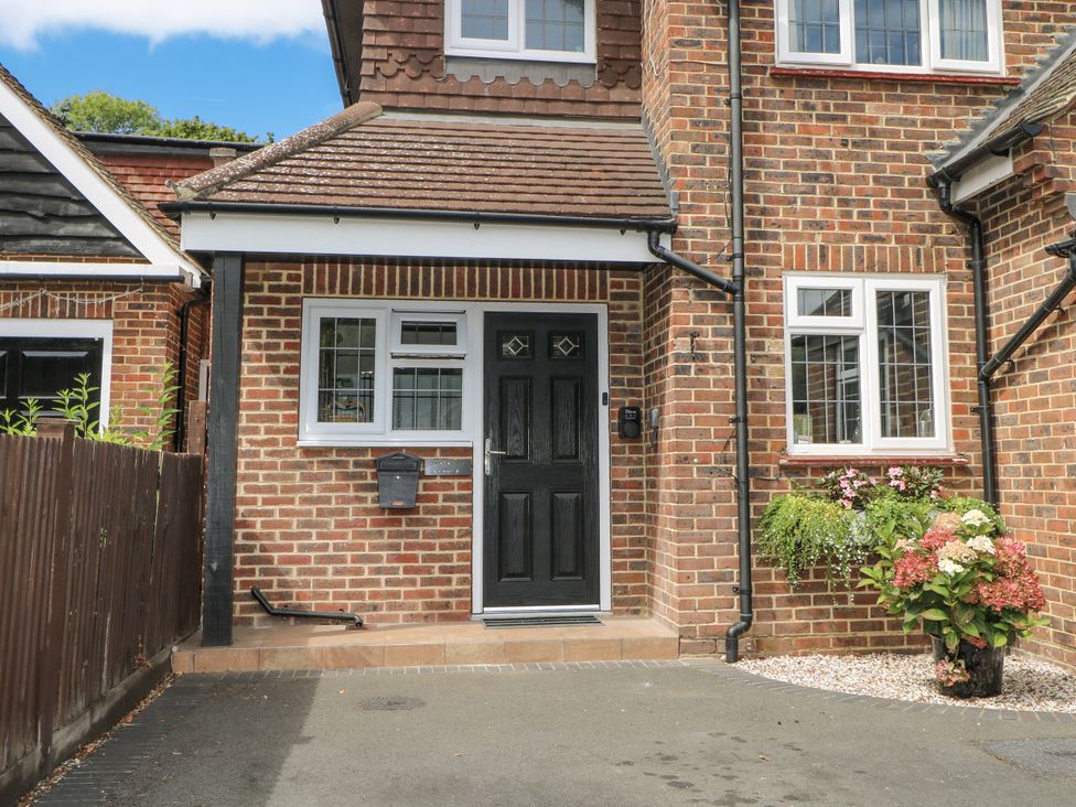 A front entrance with a black door and flower pot at Sunnyfield Cottage in 