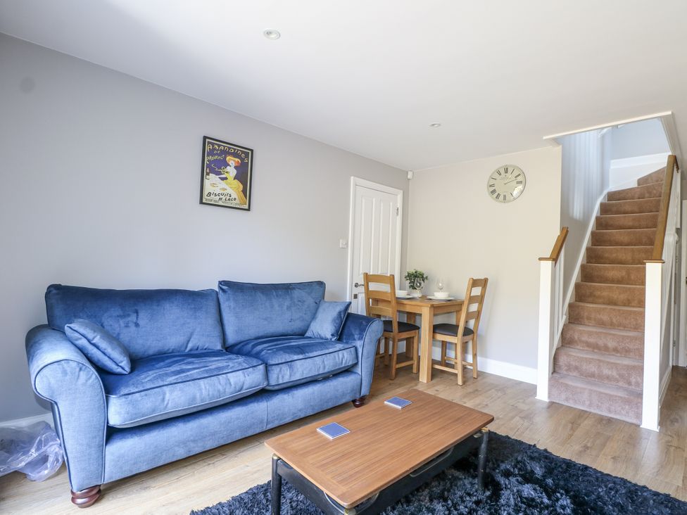 A living room with a sofa and dining table at Sunnyfield Cottage