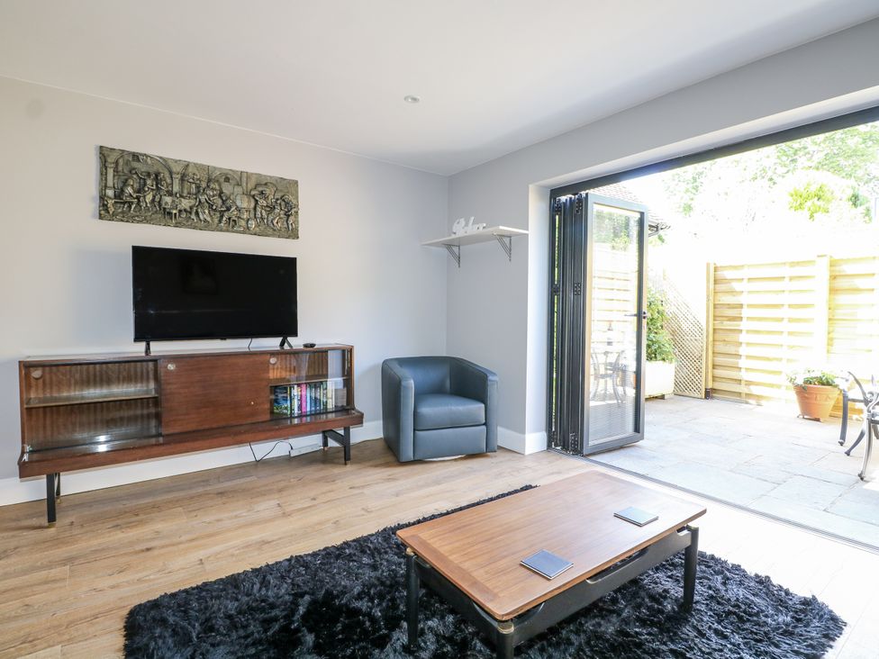 A living room with a television and sliding door at Sunnyfield Cottage