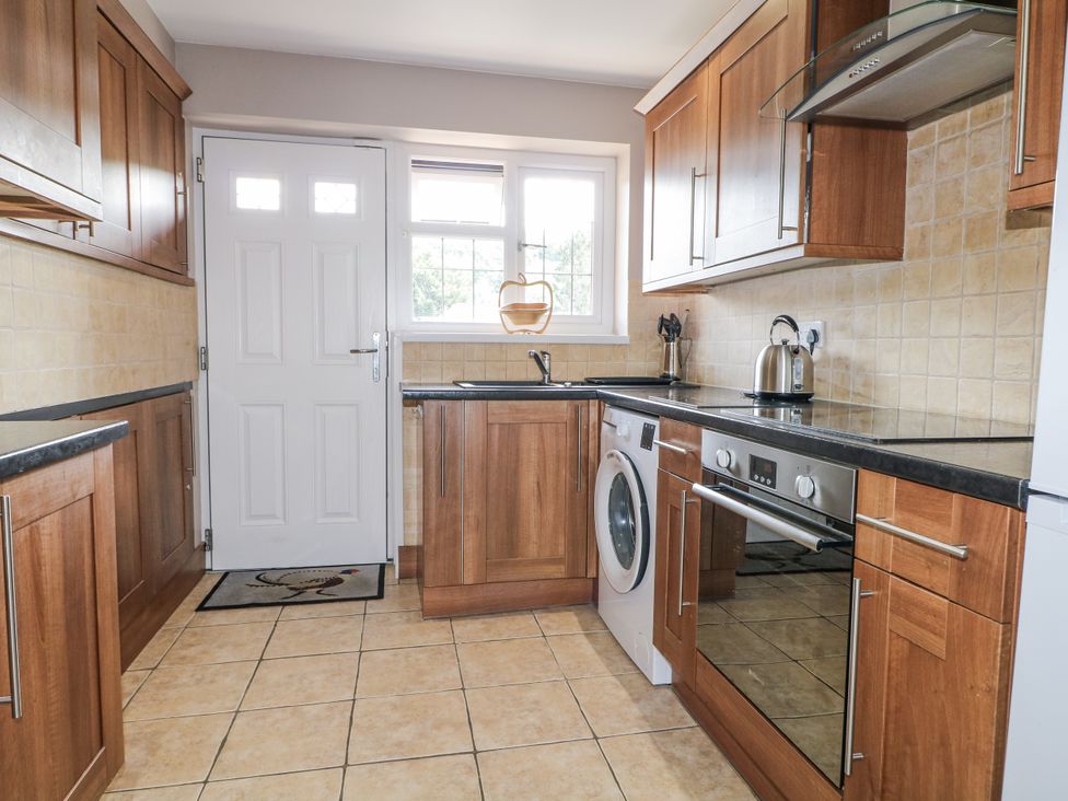 A kitchen with cabinets and appliances at Sunnyfield Cottage 