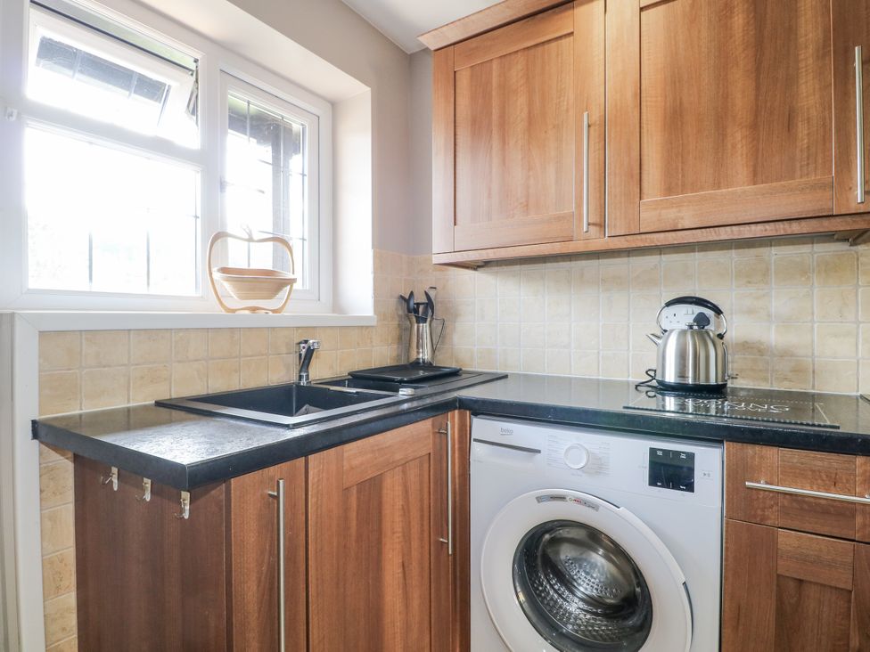 A kitchen with a washing machine and sink at Sunnyfield Cottage