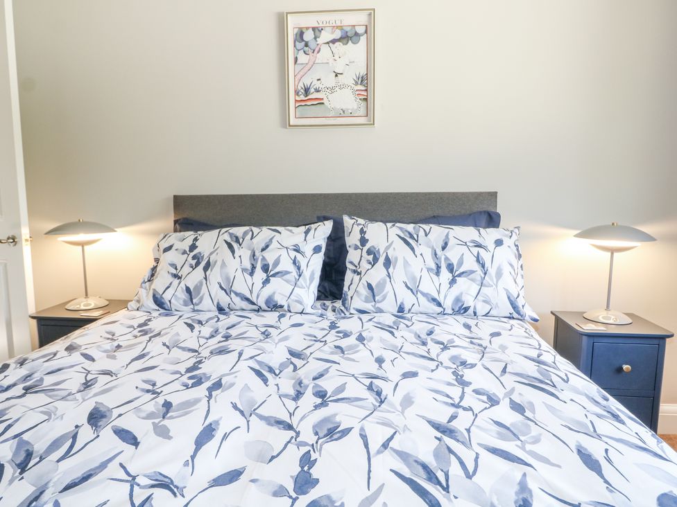 A bedroom with a bed and nightstands at Sunnyfield Cottage