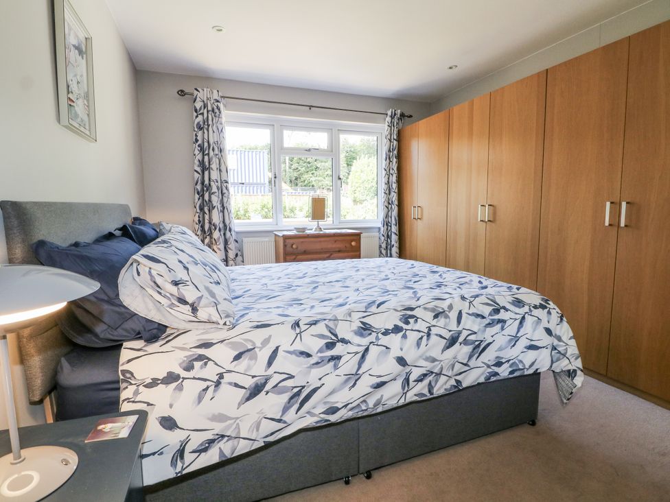 A bedroom with a bed and wardrobe at Sunnyfield Cottage