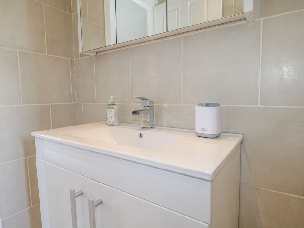 A bathroom with a sink and mirror at Sunnyfield Cottage