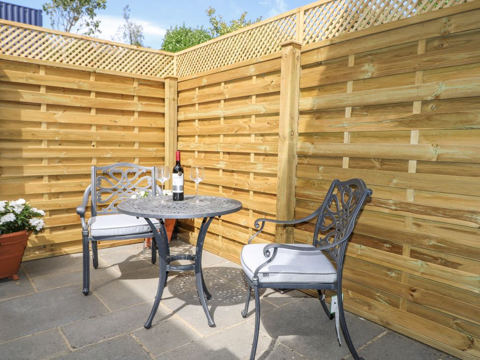 An outdoor seating area with a table and two chairs at Sunnyfield Cottage