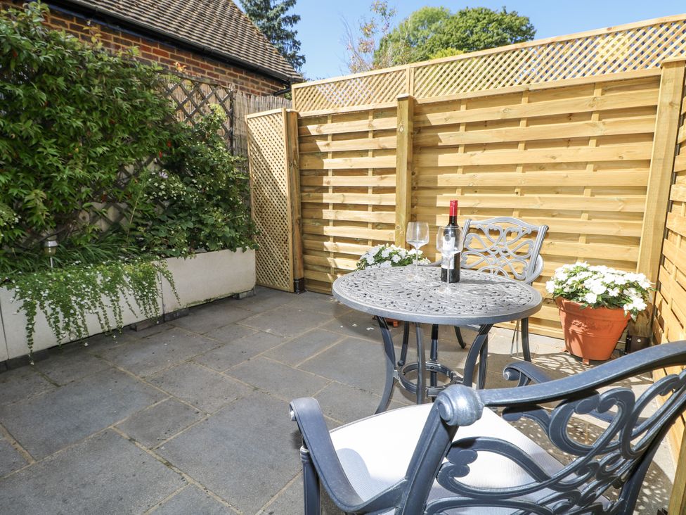 A garden patio with a table and chairs at Sunnyfield Cottage