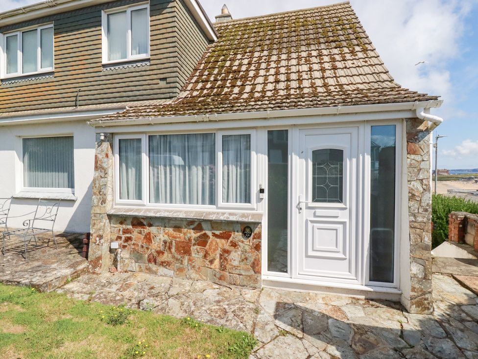 An outdoor area with a stone wall and a door at 22 Pentire Avenue Newquay