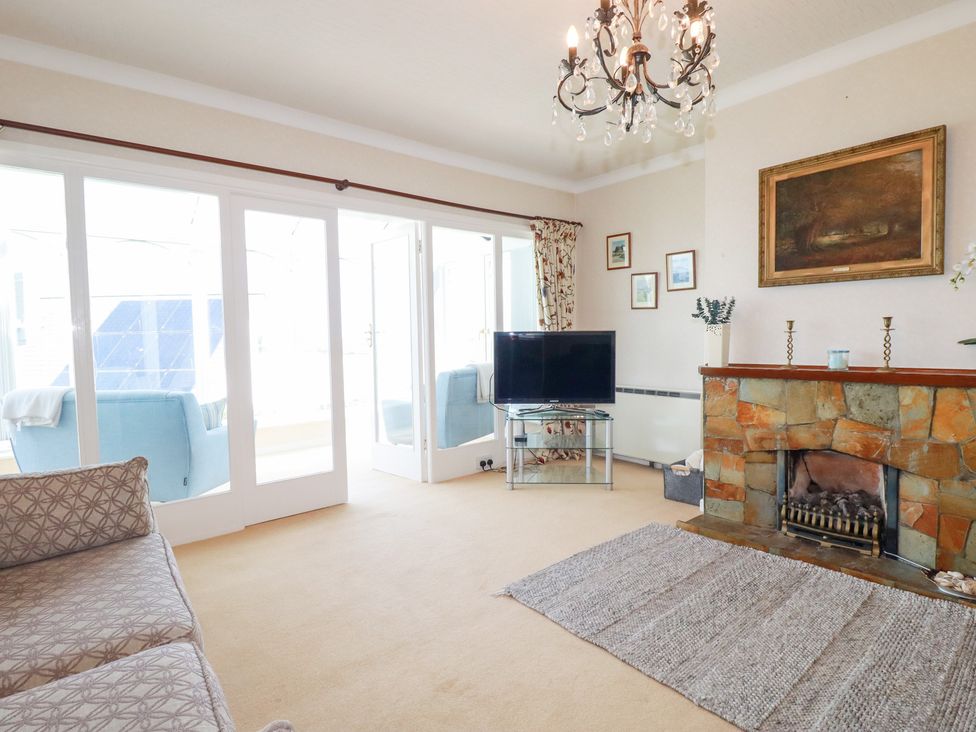 A living room with a television and a fireplace at 22 Pentire Avenue Newquay