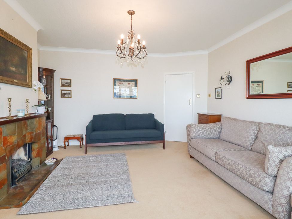 A living room with a sofa and armchair at 22 Pentire Avenue in Newquay
