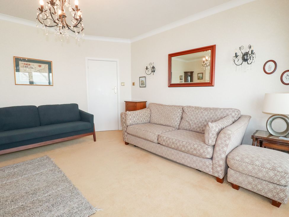 A living room with two sofas and a chandelier at 22 Pentire Avenue Newquay