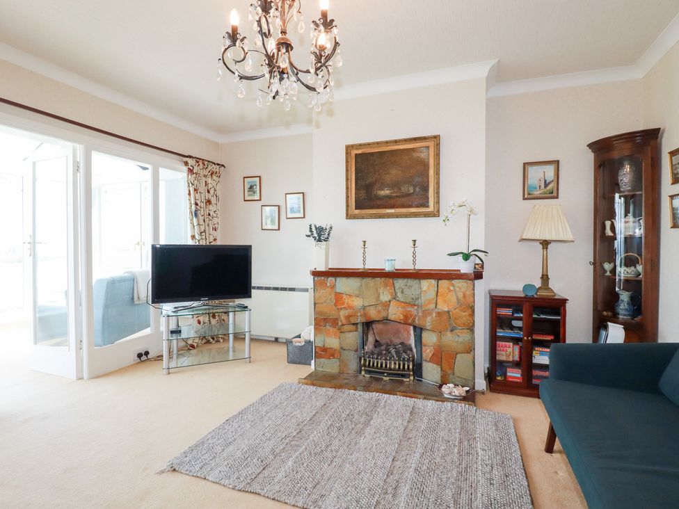 A living room with a fireplace and television at 22 Pentire Avenue Newquay