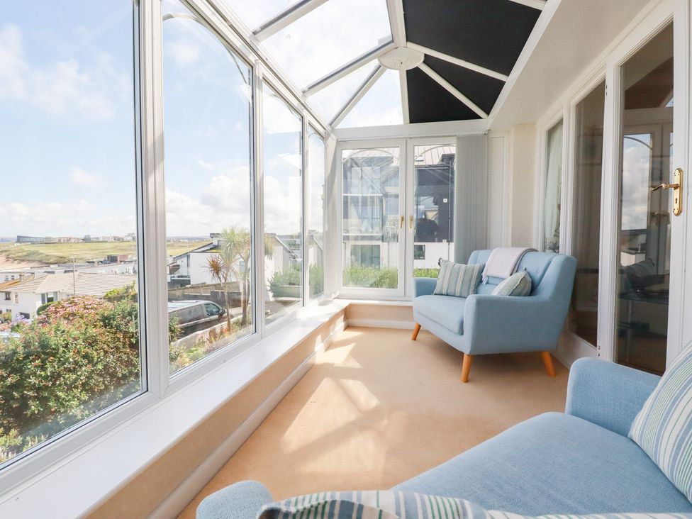 A conservatory with a sofa and views at 22 Pentire Avenue Newquay